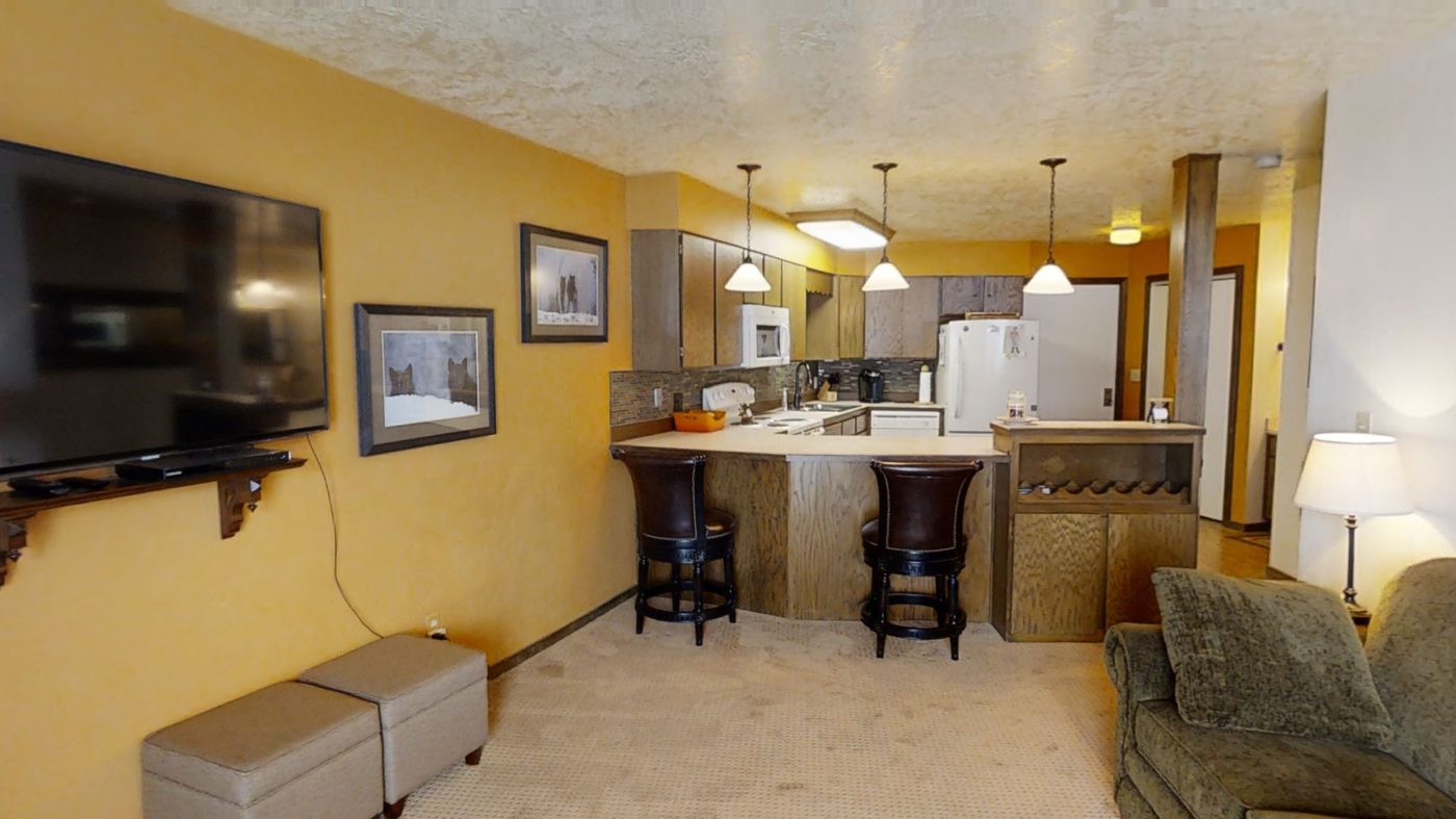 Living room with wall-mounted TV and stone fireplace